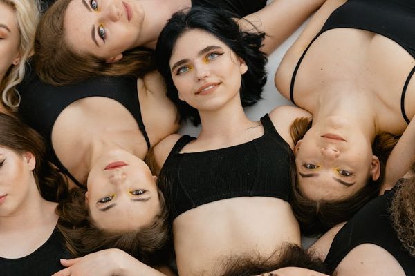 Diverse group of smiling people performing yoga poses in a bright studio.